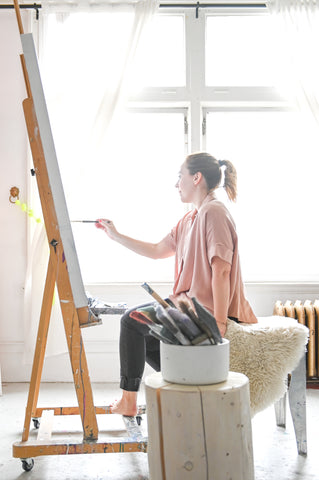 Dana Mooney Vancouver Artist painting at her easle in a bright, light filled art studio