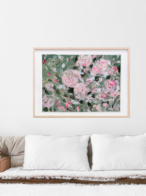 A fun and uplifting abstracted floral painting on paper. With a saje green background, shades of pastel and neon pinks pop as they seemingly float in the wind.  Shown here above a bed. 